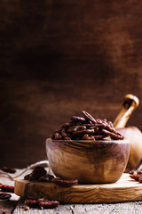 Raw pecan nuts in wooden bowl, rustic style, selective focus