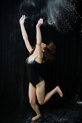 Girl dancer jumping and dancing in the white dust with flour on © AS Photo Family