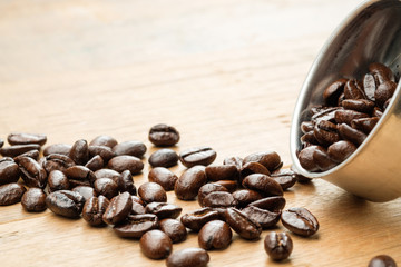 coffee beans on wooden table and in funnel of moka pot
