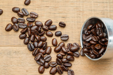 coffee beans on wooden table and in funnel of moka pot