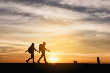 Silhouette couple over sunset background
