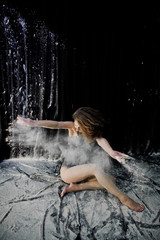 Girl dancer jumping and dancing in the white dust with flour on © AS Photo Family