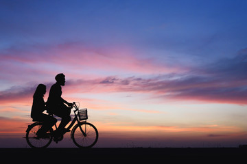 Obraz na płótnie Canvas Silhouette of couple on bike.