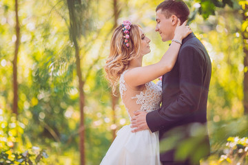 Bride and groom in a park kissing.couple newlyweds bride and groom at a wedding in nature green forest are kissing photo portrait.Wedding Couple