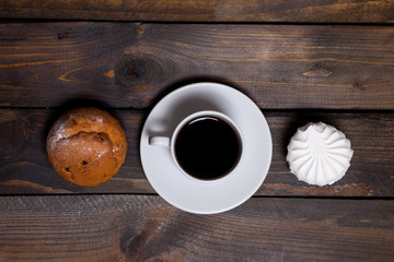 White cup of hot coffee and white marshmallows and cupcakes