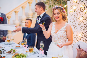 Newlyweds get an original gift butterfly from mother. Shocked and smiling bride. Holding butterfly
