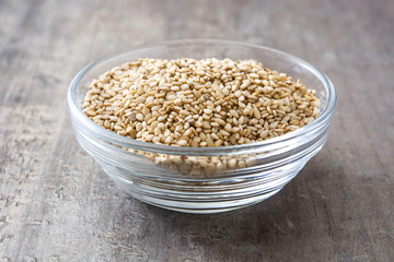 Sesame seeds in crystal bowl on wooden background
