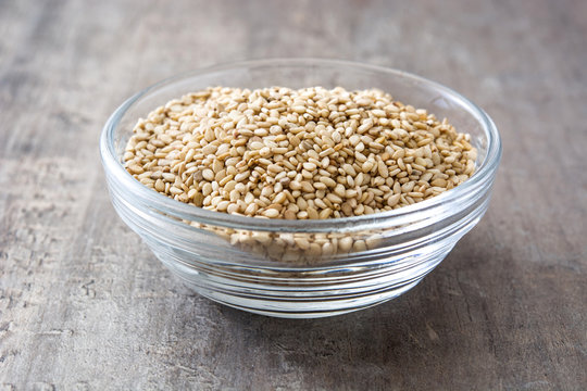 Sesame seeds in crystal bowl on wooden background
