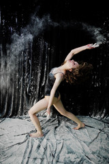 Girl dancer jumping and dancing in the white dust with flour on © AS Photo Family