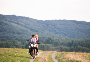 Fototapeta premium Couple in love enjoying a motorbike ride in countryside.