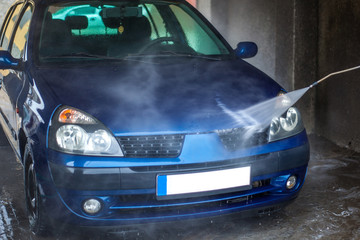 Fototapeta na wymiar Car Wash Closeup. Washing Car by High Pressure Water