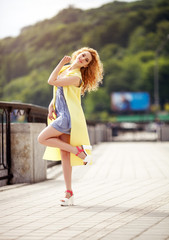 Outdoor portrait of a young beautiful happy smiling woman walking on the street. Model looking at camera.