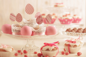 Easter cupcakes decorated with pink candy, paper eggs and ribbon