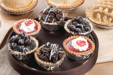 Coconut pie and chocolate mini tart on wooden background
