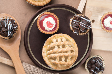 Coconut pie and chocolate mini tart on wooden background