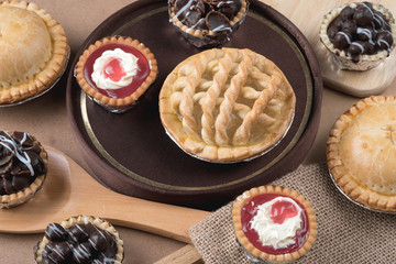 Coconut pie and chocolate mini tart on wooden background