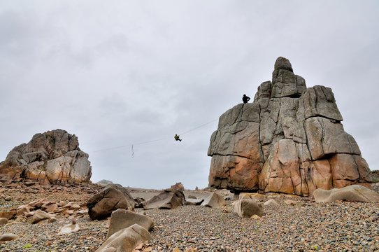Pour s'entrainer deux funambules ont tendu un cable entre deux gros rochers à Plougrescant en Bretagne