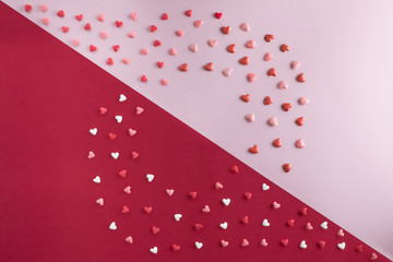 beautiful flat lay pattern of hearts with copy-space on rose quartz and red background for Valentine's Day