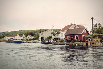 Fototapeta premium boats at a small fishing village in fjord landscape of Norway, Europe, Vintage filtered style