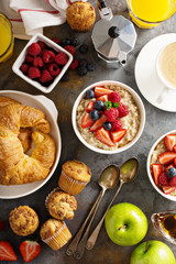 Breakfast table with oatmeal porridge, croissants and muffins