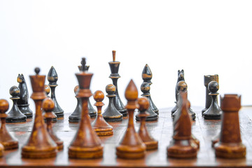 Old chess Board with wooden pieces on a white background.