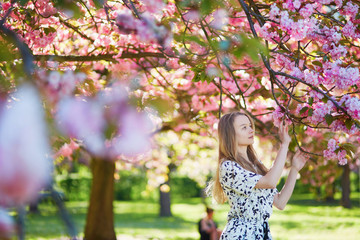 Beautiful young woman in blooming spring park