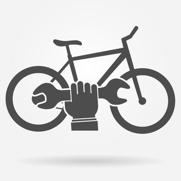 Bicycle repair icon concept. Bicycle and a hand holding spanner