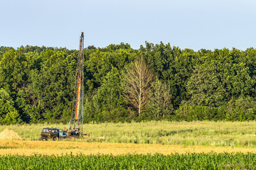 Car with a drilling derrick for geological survey on the land