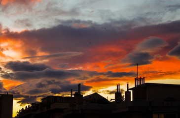 Silhouette of buildings under a red sky of clouds