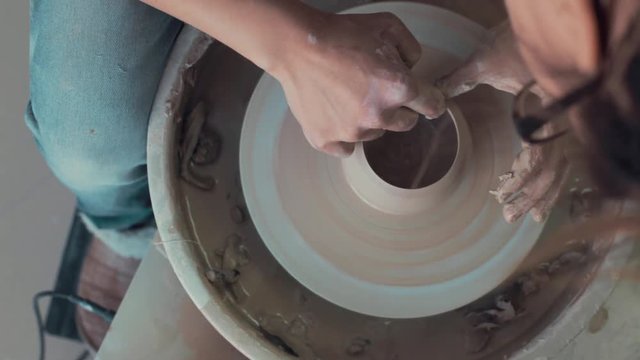 Potter Works On His Craft On A Spinning Pottery Wheel