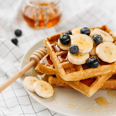 Homemade Belgian Waffles with milk and honey on table. Delicious breakfast