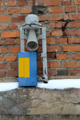 Old retro communication device on a brick wall at the railroad point