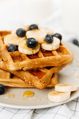 Homemade Belgian Waffles with milk and honey on table. Delicious breakfast