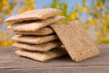 stack of crisp bread on a wooden table with blurred garden background