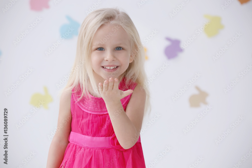 Wall mural Cute funny girl at home with Easter garlands on background