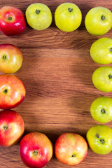 Ripe apples on a path lined with frame on the wooden background.