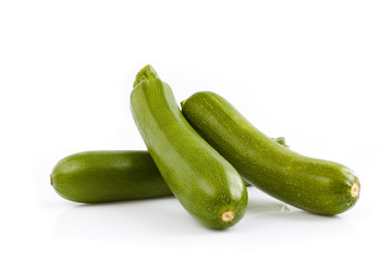Three green zucchini isolated on white background. Still-life picture taken in studio with soft-box.