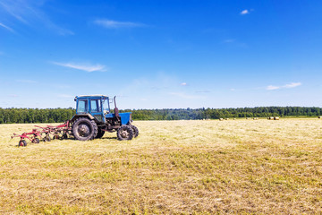 Obraz premium Old tractor in a field in the hay