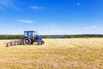 Old tractor in a field in the hay