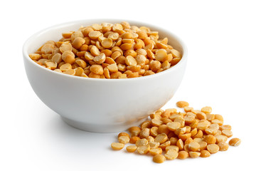 Dry yellow split peas in white ceramic bowl isolated on white. 