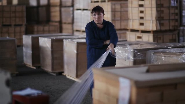 woman packer at the plant packs products. Woman packer at a factory of refractory products from refractory container packs