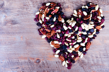 Heart of dried fruits on wooden background. Valentine's Day. Top view.