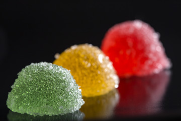 Three jelly candies over dark background