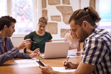 Professional male making notes from cellphone
