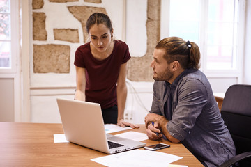 Businesswoman looking and pointing at laptop