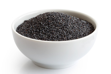 Dry poppy seeds in white ceramic bowl isolated on white.