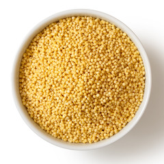 Dry millet in white ceramic bowl isolated on white from above.