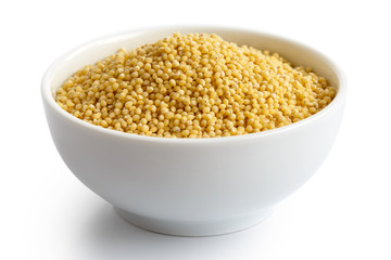 Dry millet in white ceramic bowl isolated on white.