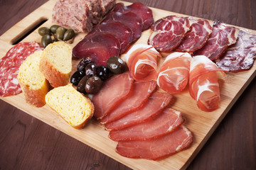 Charcuterie board with cured meat and olives