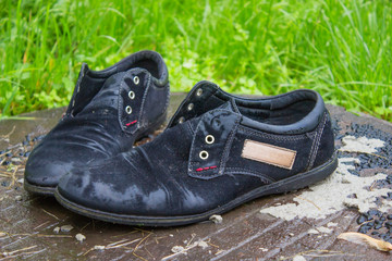 Old men's shoes. Abandoned on the street after a rain. Worn and 